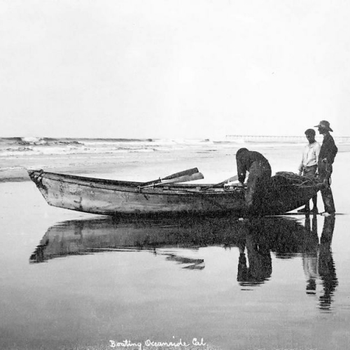 Oceanside Historical Society - Copy of 2-20 Men Next to skiff on Beach by Wisconsin Street Pier in Background